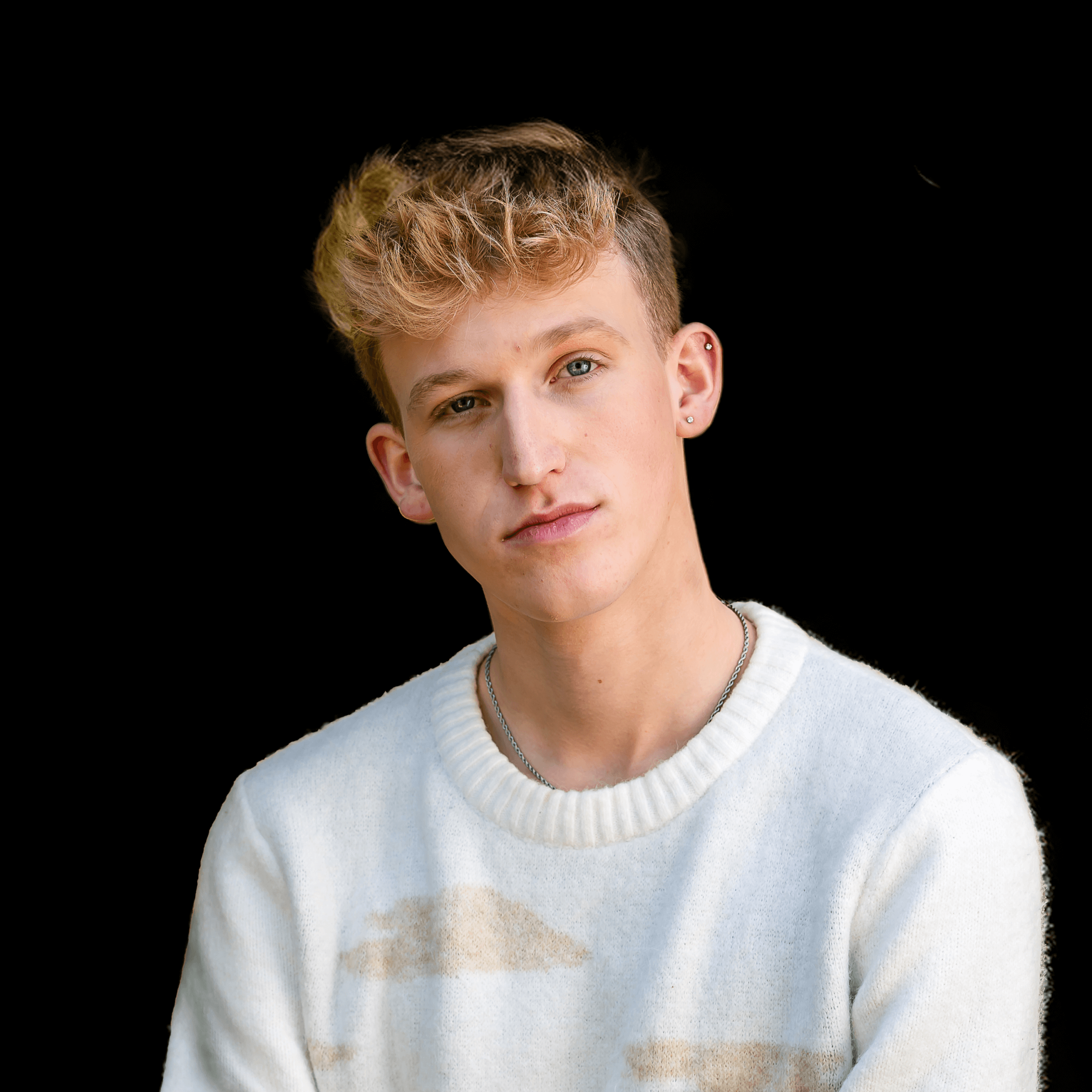 A photo of Tyler standing against a black background.